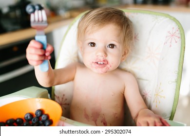 Funny Baby Eating Blueberries For The Breakfast. She Is Dirty With The Berries