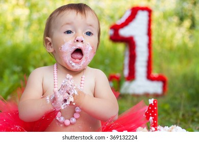Funny baby eating cake and opens her mouth