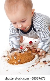 a funny baby is eating a tasty cake. isolated on a white background
