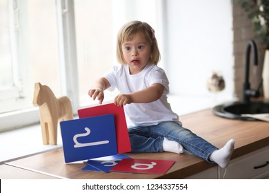 Funny Baby Toddler With Down Syndrome Learns And Plays, Real Interior. Concept Children With Special Needs And Compensation And Adaptation.