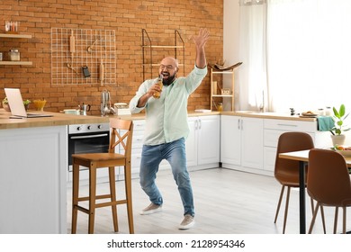 Funny Bald Man Drinking Beer And Singing In Kitchen