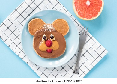 Funny Bear or Dog pancake food art for kids on bright blue background. Top view. Healthy breakfast children meal - Powered by Shutterstock