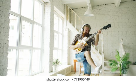 Funny Bearded Man Dance On Bed Singing And Playing Electric Guitar In Bedroom At Home