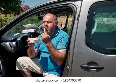 Funny Bearded Mature Man Eating Vegan Sandwich In The Car. Unhealthy Eating. Fast Food. Takeaway Food