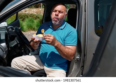 Funny Bearded Middle Aged Man Eating Vegan Sandwich On The Street Near The Car. Unhealthy Eating. Fast Food. Takeaway Food