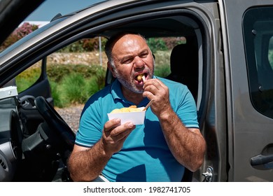 Funny Bearded Middle Aged Man Eating Vegan Sandwich On The Street Near The Car. Unhealthy Eating. Fast Food. Takeaway Food