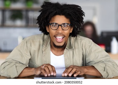 Funny Black Guy In Eyeglasses Typing On Laptop Computer And Looking At Screen With Excitement, Pov Shot Of Cheerful Nerdy Young African American Man Emotionally Reacting To Online Offer, Closeup