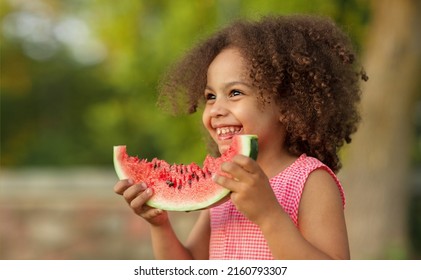 Funny Black Kid Eating Watermelon Outdoors In Hot Summer. Laughing Baby Looking At Camera, Healthy Food