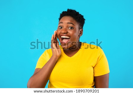Funny Black Plus-Size Woman Shouting Holding Hand Near Mouth Looking At Camera Posing Over Blue Studio Background. Hey, You Concept. Great Offer Advertisement Banner