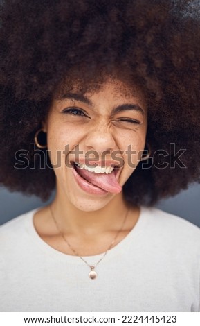 Funny, black woman and with tongue out happy, smile and content with happiness, silly and joke. African American female, young girl and with afro for happiness, crazy and positive with humor and fun.