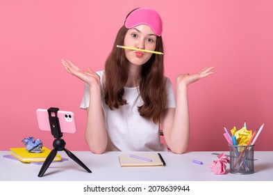 funny bored procrastination girl holding pencil pout lips, doing homework distance online education concept, young blogger shoots TikTok youtube content on the phone