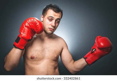 Funny Boxer Man In Knockout Over Dark Gray Background. Comic Weak Fighter With Red Sport Boxing Gloves. Waist Up Humorous Kickboxer