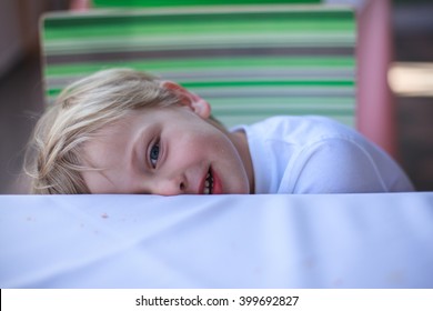 Funny Boy Hiding Under The Table At Restaurant