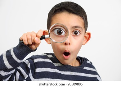funny boy looking through magnifying glass with surprise