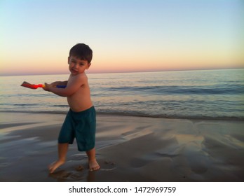 Funny boy playing and posing on the beach