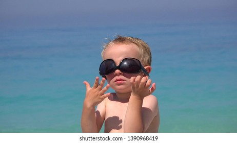 Funny Boy Try To Arrange Sunglasses, Annoyed To Fail, Beautiful Turquoise Sea