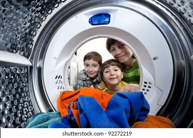 Funny boys and mother loading clothes to washing machine. View from the inside of washing machine. - Powered by Shutterstock