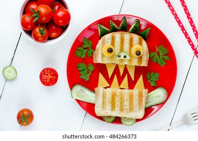 Funny Breakfast For Children - Monster Sandwich With Bread, Cucumber And Cheese On White Wooden Table Background. Creative Food Art Idea For Kids Meal Top View