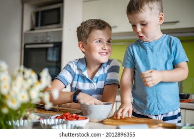 Funny Brother Male Kids Rejoicing Having Fun Cooking Summer Dessert With Fruits And Berries At Kitchen. Cute Little Boys Preparing Fresh Delicious Baking Food At Home Having Positive Emotion Together