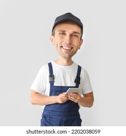 Funny Car Mechanic With Big Head And Tablet Computer On Light Background