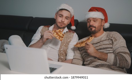 Funny Caucasian Gay Couple Watching Movies On The Laptop On The Christmas Eve And Eating Pizza. High Quality Photo