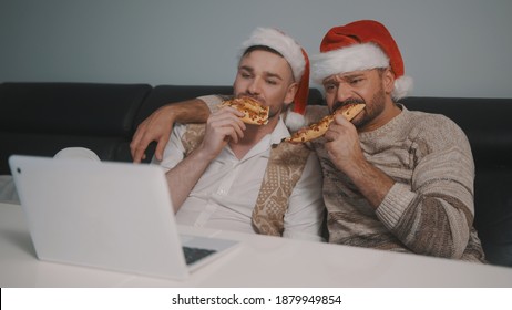 Funny Caucasian Gay Couple Watching Movies On The Laptop On The Christmas Eve And Eating Pizza. High Quality Photo