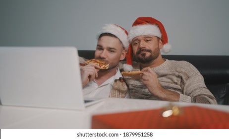 Funny Caucasian Gay Couple Watching Movies On The Laptop On The Christmas Eve And Eating Pizza. High Quality Photo