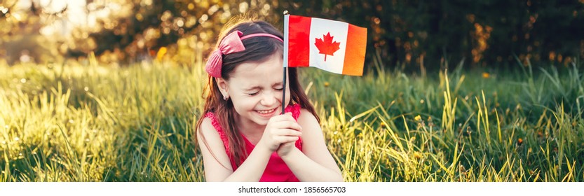 Funny Caucasian Girl Holding Canadian Flag. Laughing Child In Park Holding Canada Flag. Kid Citizen Celebrating Canada Day Holiday On First Day Of July Outdoor. Web Banner Header.