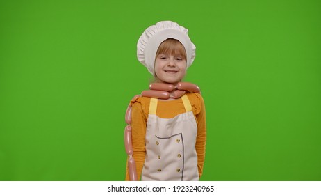 Funny Caucasian Teen Child Girl Dressed As Cook Chef In Apron Dancing With Sausages, Fooling Around, Making Faces Isolated On Chroma Key Background. Slow Motion. Cooking School, Children Education