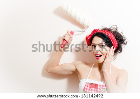 funny charming young brunette woman beautiful pinup girl paint platen wall with roller happy smiling & looking at camera on white background closeup portrait