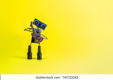 Funny Cheerful Cute Charming Robot Plays The Guitar On A Yellow Background