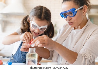 Funny chemistry. Closeup cropped scientific experiment at home. Laboratory tests for school homework. Parent mother with daughter kid making chemical test at home kitchen. - Shutterstock ID 2097347929