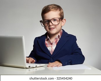 funny child with computer.Young business boy. smiling kid in glasses