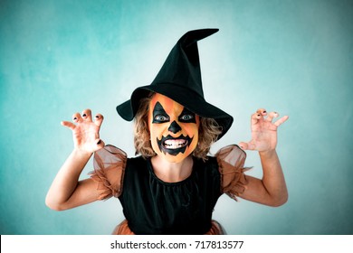 Funny Child Dressed Witch Costume. Kid Painted Terrible Pumpkin. Halloween Autumn Holiday Concept