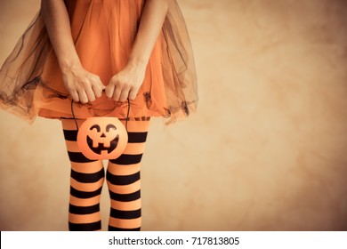 Funny Child Dressed Witch Costume. Kid Waiting Candy With Pumpkin Container. Halloween Autumn Holiday Concept