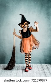 Funny Child Dressed Witch Costume. Kid Painted Terrible Pumpkin. Halloween Autumn Holiday Concept