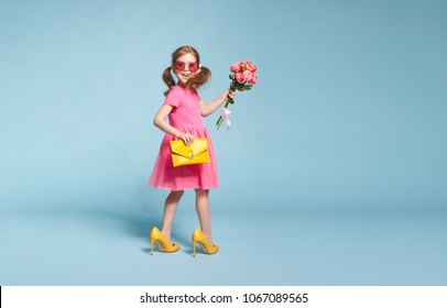 funny child girl fashionista in big mother's yellow shoes on colored background
 - Powered by Shutterstock