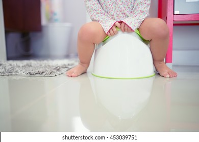 funny child girl sitting on chamberpot, Children's legs hanging down from a chamber-pot.
