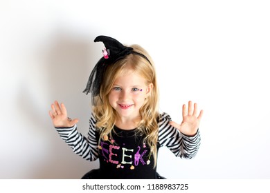 Funny Child Girl In Witch Costume For Halloween On A White Background. Happy Halloween.