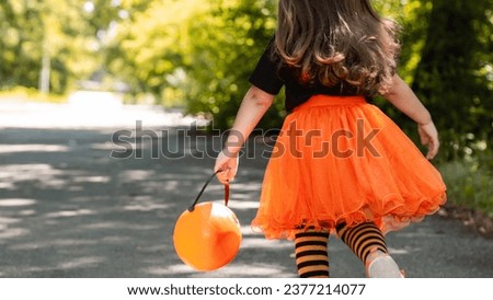 funny child girl in witch costume for halloween with pumpkin jack