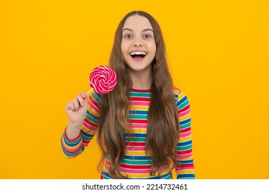 Funny Child With Lollipop Over Yellow Isolated Background. Sweet Childhood Life. Teen Girl With Yummy Caramel Lollipop, Candy Shop. Teenager With Sweet Sucker.