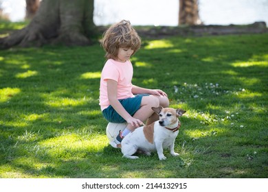 Funny Child Playing With Dog In The Park. Kid Caress Dog.