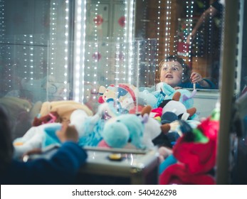 Funny child playing in a vending machine pullout soft toys