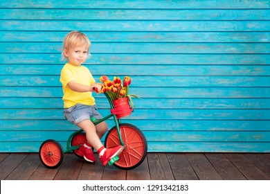 Funny Child Riding Bike. Happy Kid Having Fun At Home. Spring Family Holiday Concept. Mother's Day