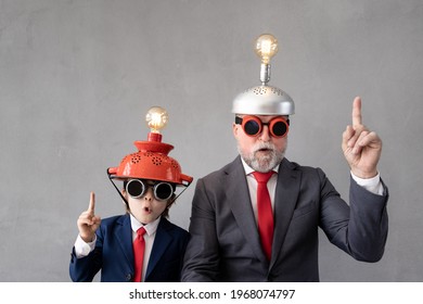 Funny child and senior man pretend to be businessmen. Grandfather and kid playing at home. Education, start up and business idea concept