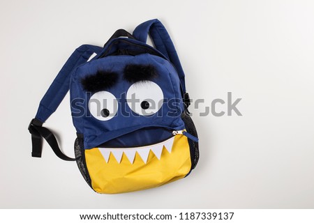 Funny children backpack with monster face, big eyes and open mouth, open pocket school bag, back to school or Halloween concept