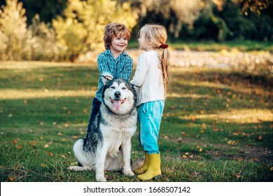 Funny Children brother and sister and dog together in park. Child 5 years old. Kids with dog walking away. Happy little kids and dog together as friends as love of animals concept