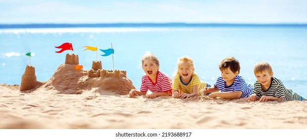 Funny children lying on the sand of the seashore. Building sandcastle. Concept of the family vacation, tourism and friendship. - Powered by Shutterstock
