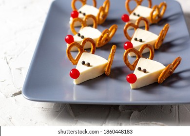 Funny Christmas Snack In A Shapes Of Deer For Kids Party. Concept New Year Food From Cheese And Pretzels On White Background