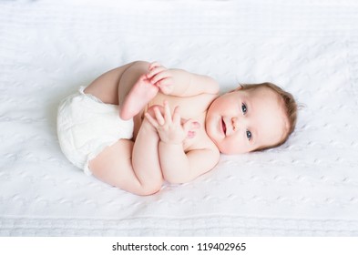 Funny chubby baby playing with its feet